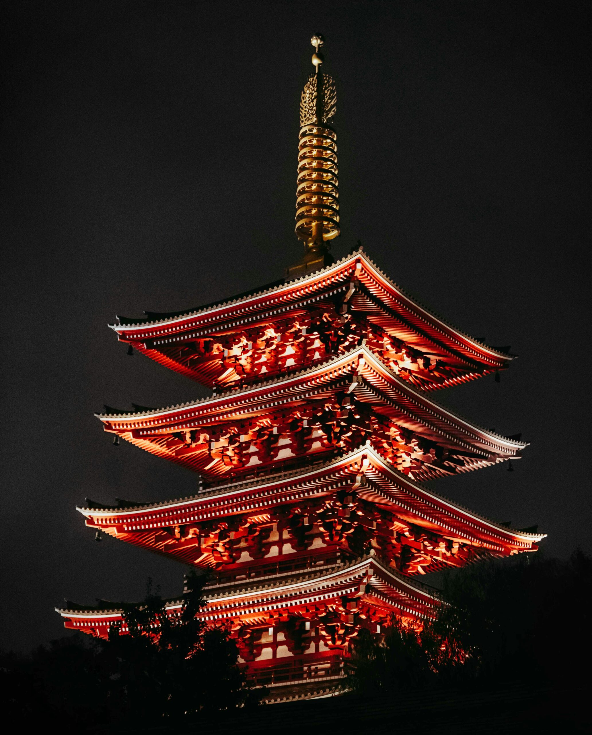 A beautifully lit traditional Japanese pagoda at night in Tokyo, showcasing vibrant architecture.